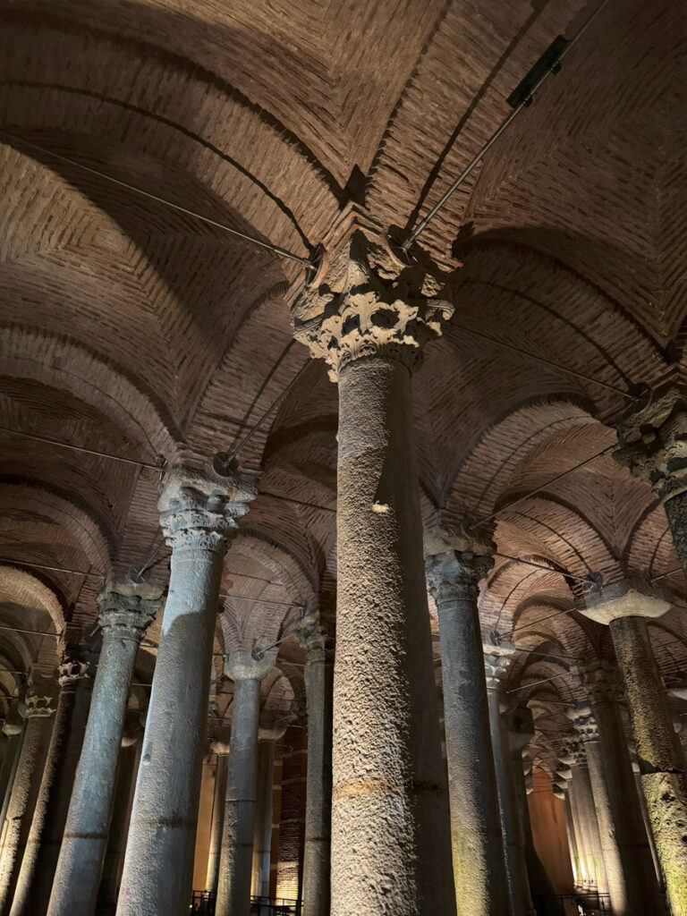 Close-up view of the unique capitals of marble columns inside the Basilica Cistern, showing Corinthian and other decorative styles under soft lighting.