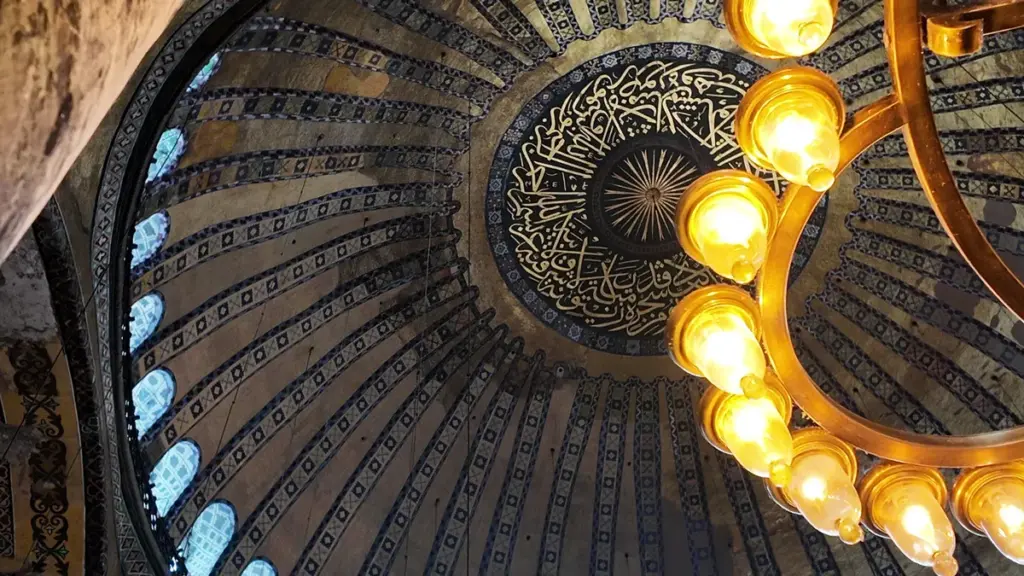 “Ceiling of the upper gallery in Hagia Sophia, Istanbul, illuminated by golden lamps symbolizing light and faith.”
