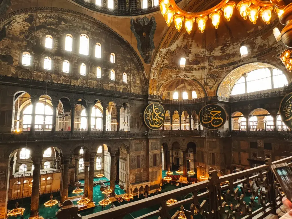 View of the Hagia Sophia dome from the second floor, showing one of the four Seraphim angels with six wings watching over the dome. The photo captures the golden light filtering through the upper gallery.