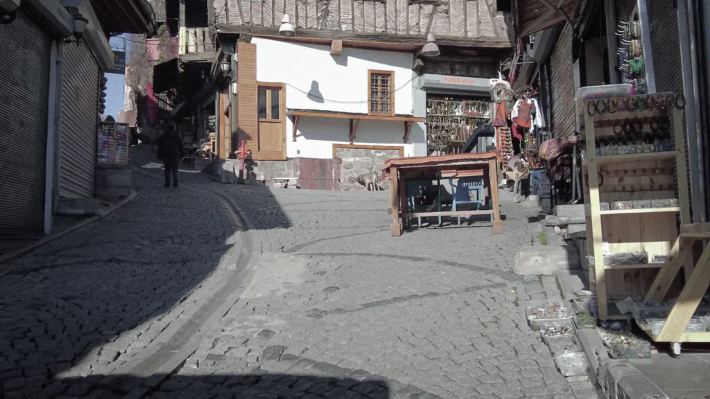 Barış walking through an old quiet street in Ulus, Ankara at dawn