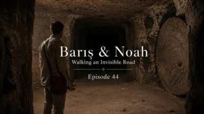Barış stands silently in a narrow underground passage inside Derinkuyu Underground City, facing the darkness ahead in a quiet moment of psychological mystery.