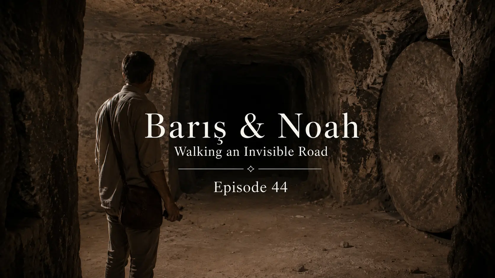 Barış stands silently in a narrow underground passage inside Derinkuyu Underground City, facing the darkness ahead in a quiet moment of psychological mystery.