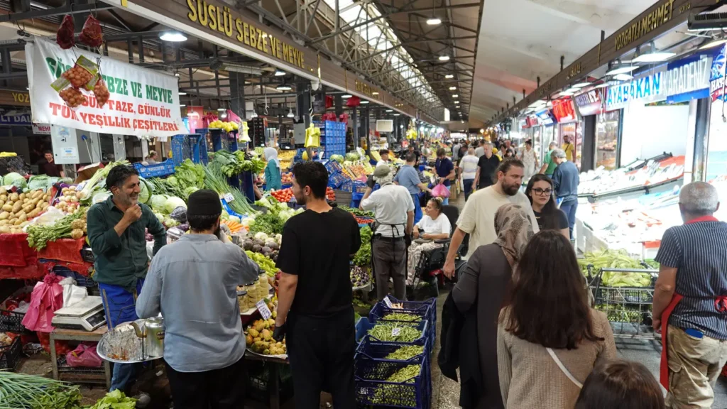 Shoppers walking between produce and fish stalls inside Ulus Hali in Ankara