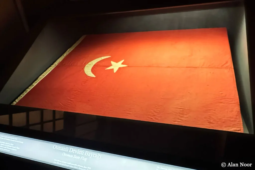Historic Ottoman State Flag with a white crescent and star on red fabric, displayed at Ankara Republic Museum in Türkiye.